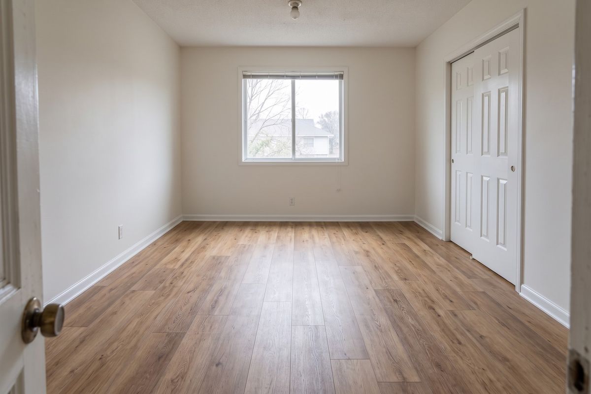 Worn bedroom carpet, now warm wood-look plank, after the work