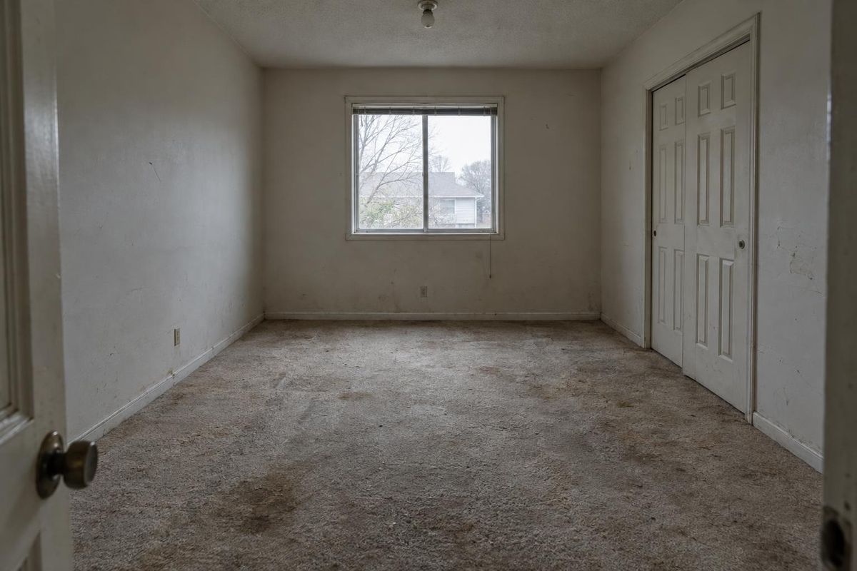 Worn bedroom carpet, now warm wood-look plank, before
